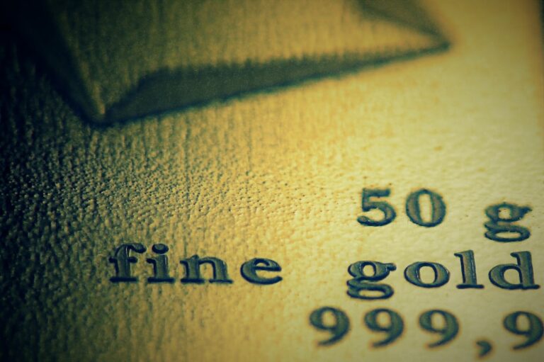 Goldbarren mit Finanzcharts symbolisieren Investition in Gold ETF sinnvoll
