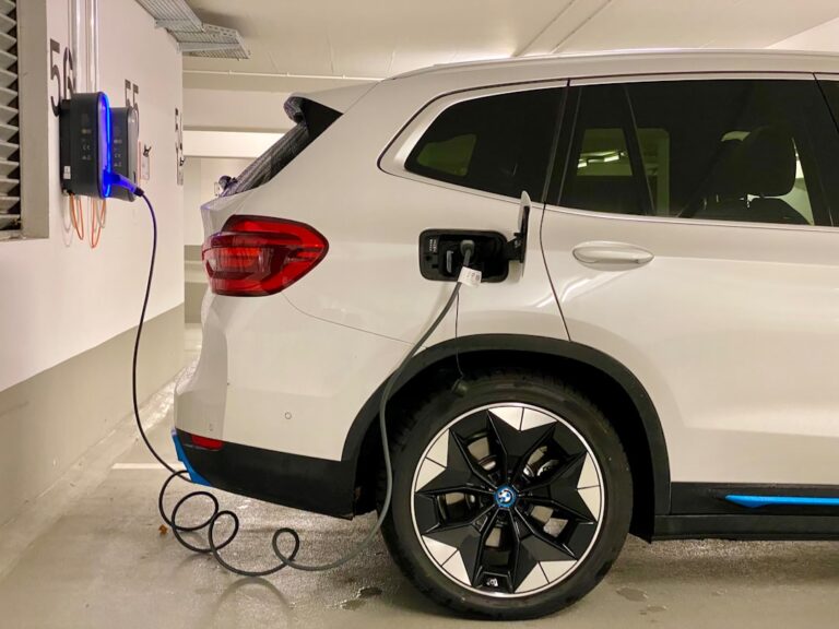 Moderne Wallbox an Hauswand lädt Elektroauto sicher und effizient zu Hause